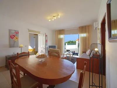 a living room with a wooden table and a dining room at Holiday Home Monte Novo by Interhome in Paderne