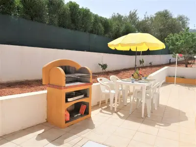 a patio with a table and a yellow umbrella at Holiday Home Monte Novo by Interhome in Paderne