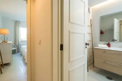 a bathroom with a sink and a white door at Solar do Golfe apt 101 - By Vilamoura Sun in Vilamoura
