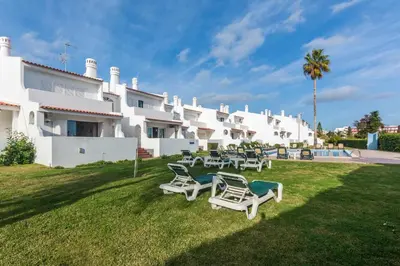 a group of lawn chairs in front of a building at Oura Parque Apartamentos Turisticos in Albufeira