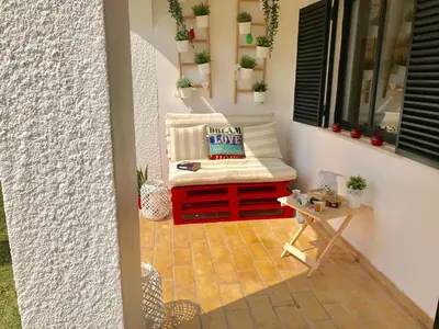 a porch with a bench and a window with plants at VILAMOURA FÉRIAS by Ethnic Ocean in Vilamoura