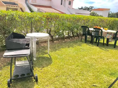a grill in a yard with chairs and a table at VILAMOURA FÉRIAS by Ethnic Ocean in Vilamoura