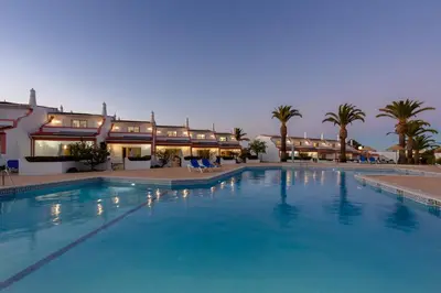 a large swimming pool in front of a hotel at Moradias Villas Joinal in Albufeira