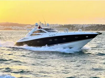 a black and white boat in the water at Marina Sagres Apartment in Vilamoura