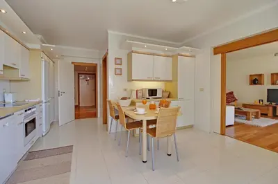 a kitchen and dining room with a table and chairs at Marina Sagres Apartment in Vilamoura