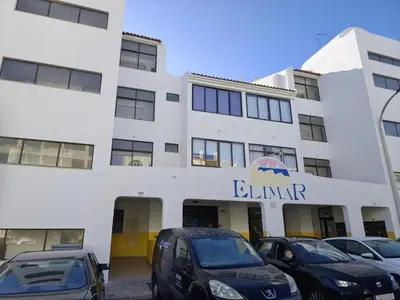 a building with cars parked in front of it at Albufeira INN - Elimar 3 T1 in Albufeira