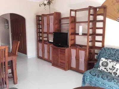 a living room with a tv and a couch and a table at Albufeira INN - Elimar 5 T1 in Albufeira