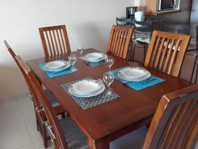 a wooden table with plates and wine glasses on it at Albufeira INN - Elimar 5 T1 in Albufeira