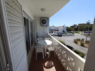a balcony with a table and chairs and a street at Praia dos Aveiros T1 - Albufeira INN in Albufeira
