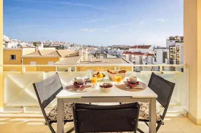 a table on a balcony with a view of a city at Garden Hill Relax & Old Town by OCvillas in Albufeira