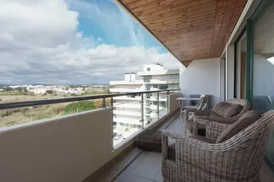 a balcony with two chairs and a view of a building at Marina Vilamoura Aquamar 504 by VilamouraSun in Vilamoura