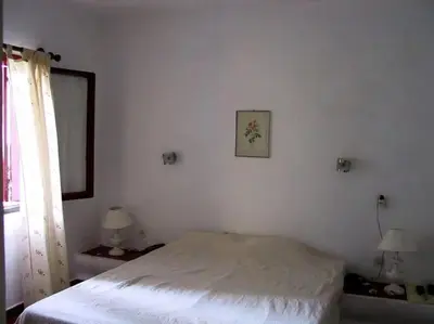 a white bedroom with a bed and a window at House with beautiful garden and swimming pool in Quarteira