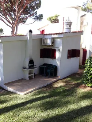 a backyard patio with a pizza oven in a house at House with beautiful garden and swimming pool in Quarteira