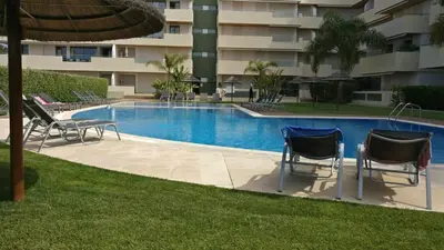 a swimming pool with two chairs and a table at Marina Vilamoura - Aquamar 301 - By Vilamoura Sun in Vilamoura
