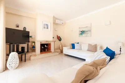 a living room with a white couch and a fireplace at Vila dos Girassóis - BlueSea in Albufeira