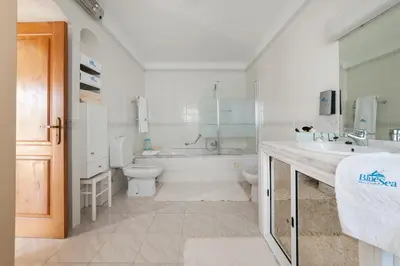 a bathroom with a tub and a toilet and a sink at Vila dos Girassóis - BlueSea in Albufeira
