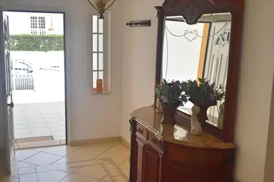 a wooden dresser with a mirror and flowers on it at Villa Coelho - By Algarkasa in Albufeira