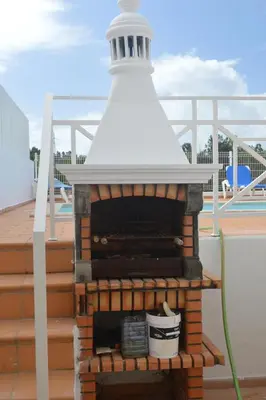 a brick fireplace with a lighthouse on a roof at Villa Coelho - By Algarkasa in Albufeira