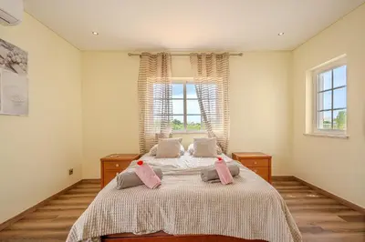 a bedroom with a bed with pink pillows on it at Villa Monica - POOL HEATED - By Algarkasa in Albufeira