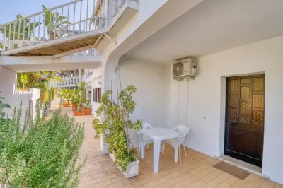 a patio with a white table and chairs and a staircase at Casa Teles in Quarteira