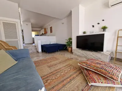 a living room with a couch and a large tv at Windmill Hill in Albufeira