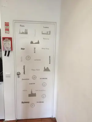a white door with a wall with cities on it at Charmosous Flat in Albufeira
