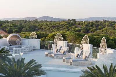 a patio with chairs and a view of the mountains at Conrad Algarve in Quinta do Lago