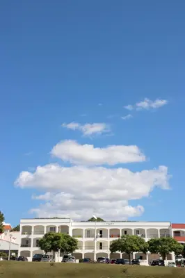 a white building with trees in front of it at Apartamentos King's in Quarteira