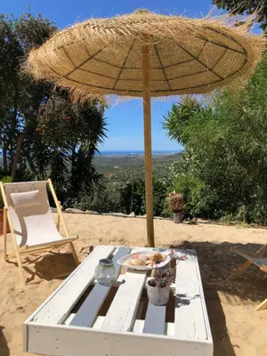 an umbrella and a table with a plate of food at Felicidade in Loulé