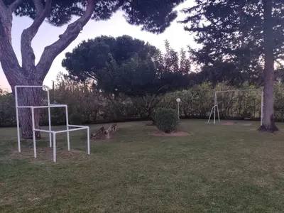 a white chair sitting in a field next to a tree at Vieira apartment 1 in Quarteira
