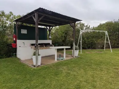a picnic shelter with a picnic table in a field at Vieira apartment 1 in Quarteira