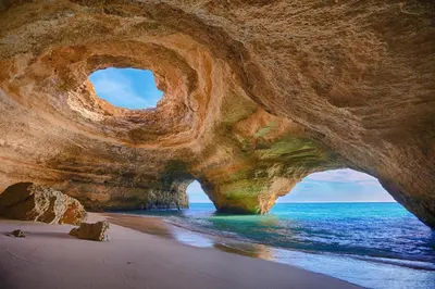 a large rock formation on a beach with the ocean at Apartamento AH in Guia