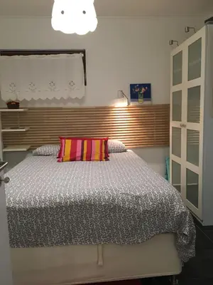 a bedroom with a large bed with a colorful pillow at Estúdio tranquilo praia da Falésia in Albufeira