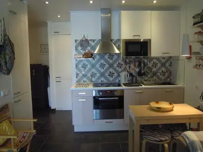 a kitchen with white cabinets and a stove top oven at Estúdio tranquilo praia da Falésia in Albufeira