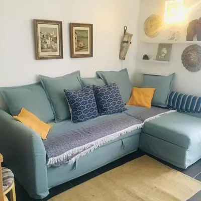 a blue couch with pillows in a living room at Estúdio tranquilo praia da Falésia in Albufeira