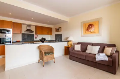 a living room with a couch and a kitchen at Vista das Ondas by Algarneto in Albufeira