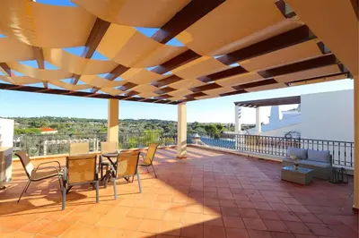 a patio with a table and chairs on a roof at Villa Heloise 139 - Clever Details in Vilamoura