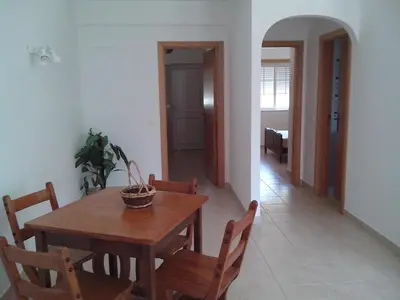 a dining room with a wooden table and chairs at Albufeira 1 bedroom apartment 5 min from Falesia beach and close to center E in Albufeira