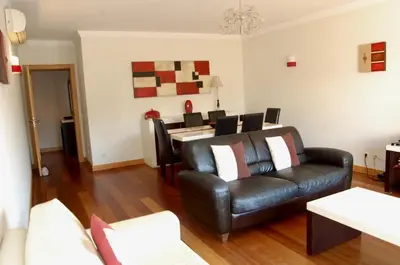 a living room with a leather couch and a table at Corcovada in Albufeira