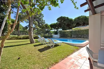 a swimming pool with chairs and trees in a yard at Perfect Retreat Overlooking Pinhal Golf Course, Private pool, Off-street parking in Loulé
