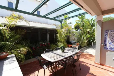 a table and chairs on a patio with plants at Villa Bonito 56 - Clever Details in Vilamoura