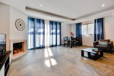 a living room with a fireplace and a table at Falesia Beach A in Roja- Pé