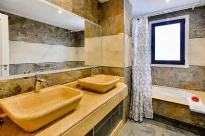 a bathroom with a wooden sink and a tub at Falesia Beach A in Roja- Pé