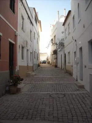 a cobblestone street in an alley between buildings at Vivenda João Damas in Albufeira