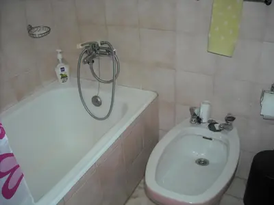 a bathroom with a tub and a toilet and a shower at Vivenda João Damas in Albufeira