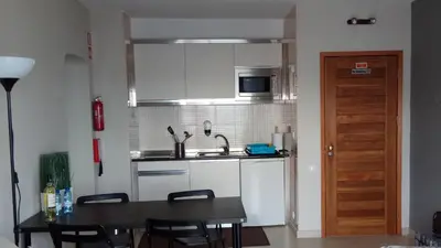 a kitchen with a table and a sink and a microwave at Apartamento de Praia - Albufeira in Albufeira
