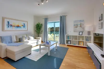 a living room with a white couch and a table at Marina Bay Residence in Albufeira