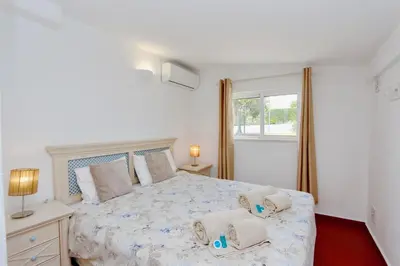 a bedroom with a large bed with two pillows at Villa Molgard 61 - Clever Details in Vilamoura