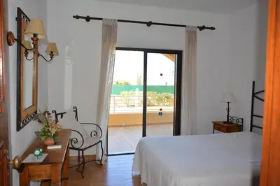 a bedroom with a bed and a door to a balcony at Villa Paraiso - 4 Bedrooms and pool in Albufeira