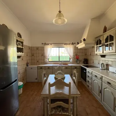 a kitchen with a table and a refrigerator at Villa Paraiso - 4 Bedrooms and pool in Albufeira